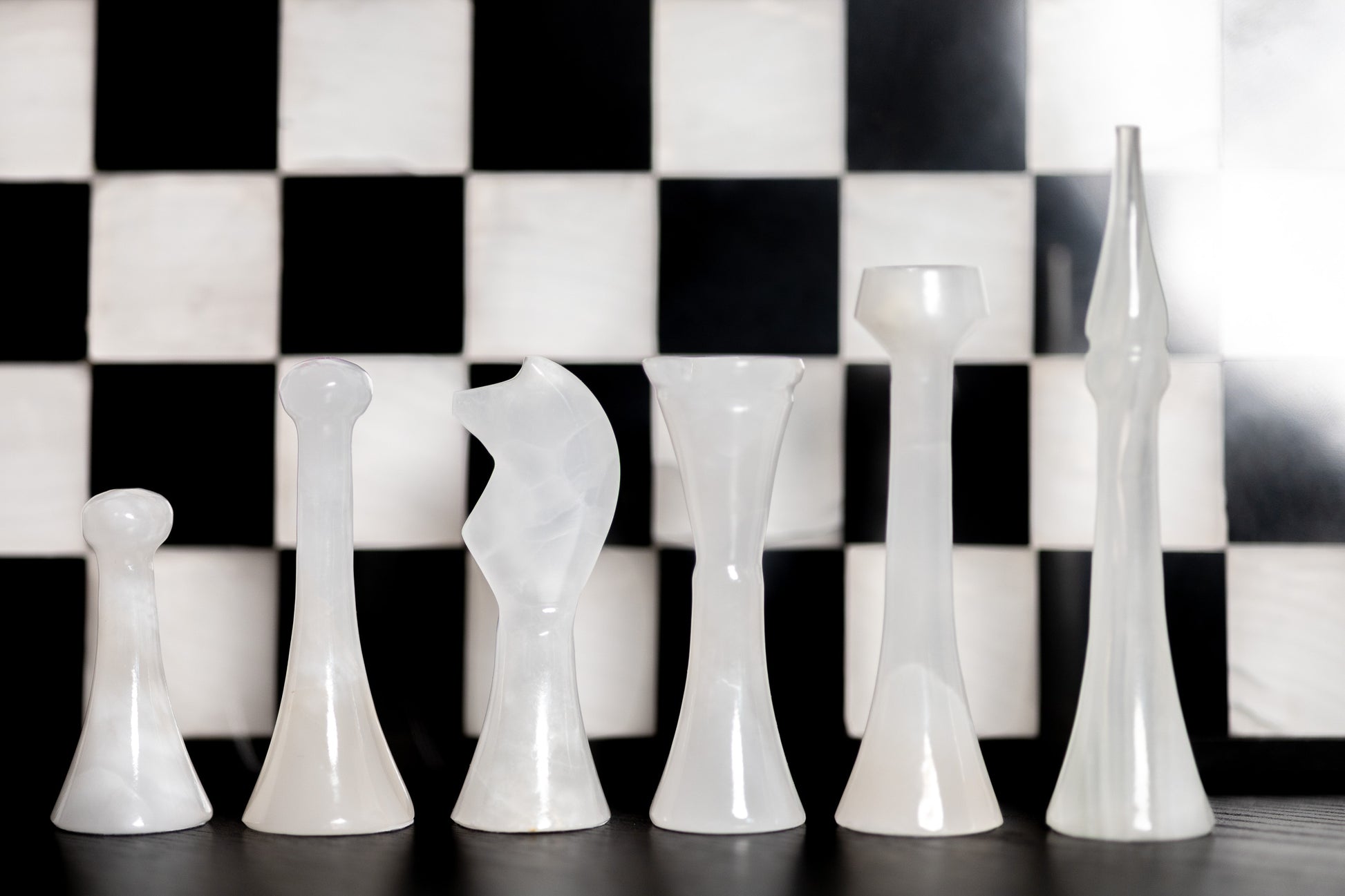 Exklusive Detailaufnahme der weißen Onyx-Schachfiguren von Marmonix, die die luxuriöse, leicht transluzente Textur und das feine natürliche Muster des edlen Natursteins hervorhebt.