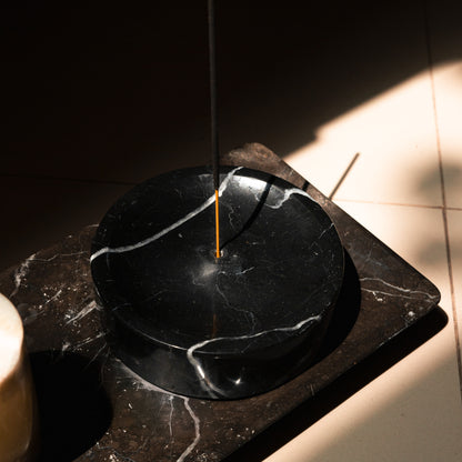 Runde schwarze Marmor-Räucherschale von Marmonix, harmonisch platziert für ein meditatives und edles Raumambiente.