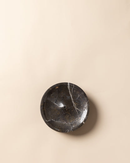 Runde Draufsicht auf die minimalistische Räucherschale aus schwarzem Marmor, von oben fotografiert.