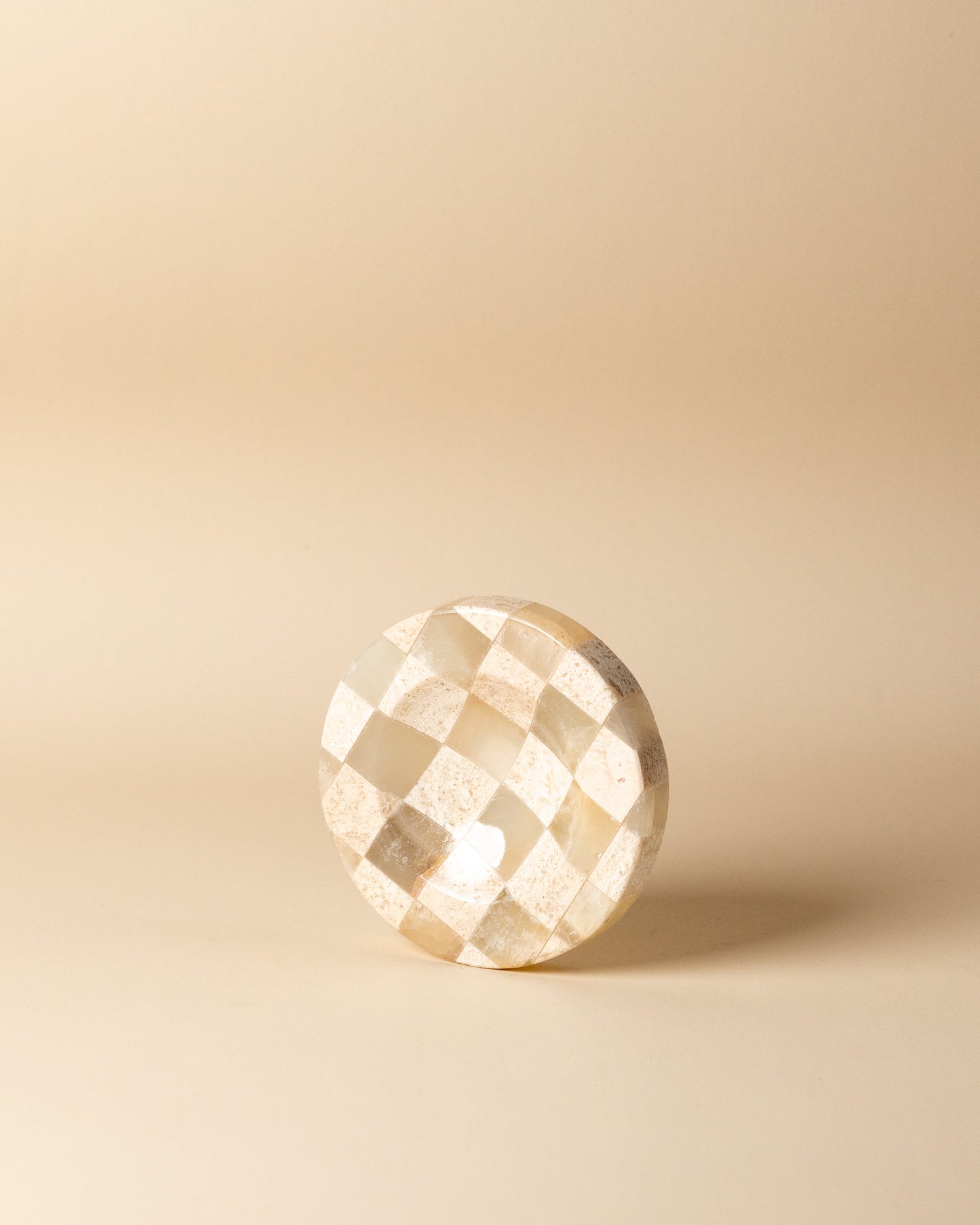 Geometrische Draufsicht auf das kleine, karierte Natursteintablett im Schachmuster von Marmonix, elegant inszeniert als luxuriöse Schmuck- oder Schlüsselablage.