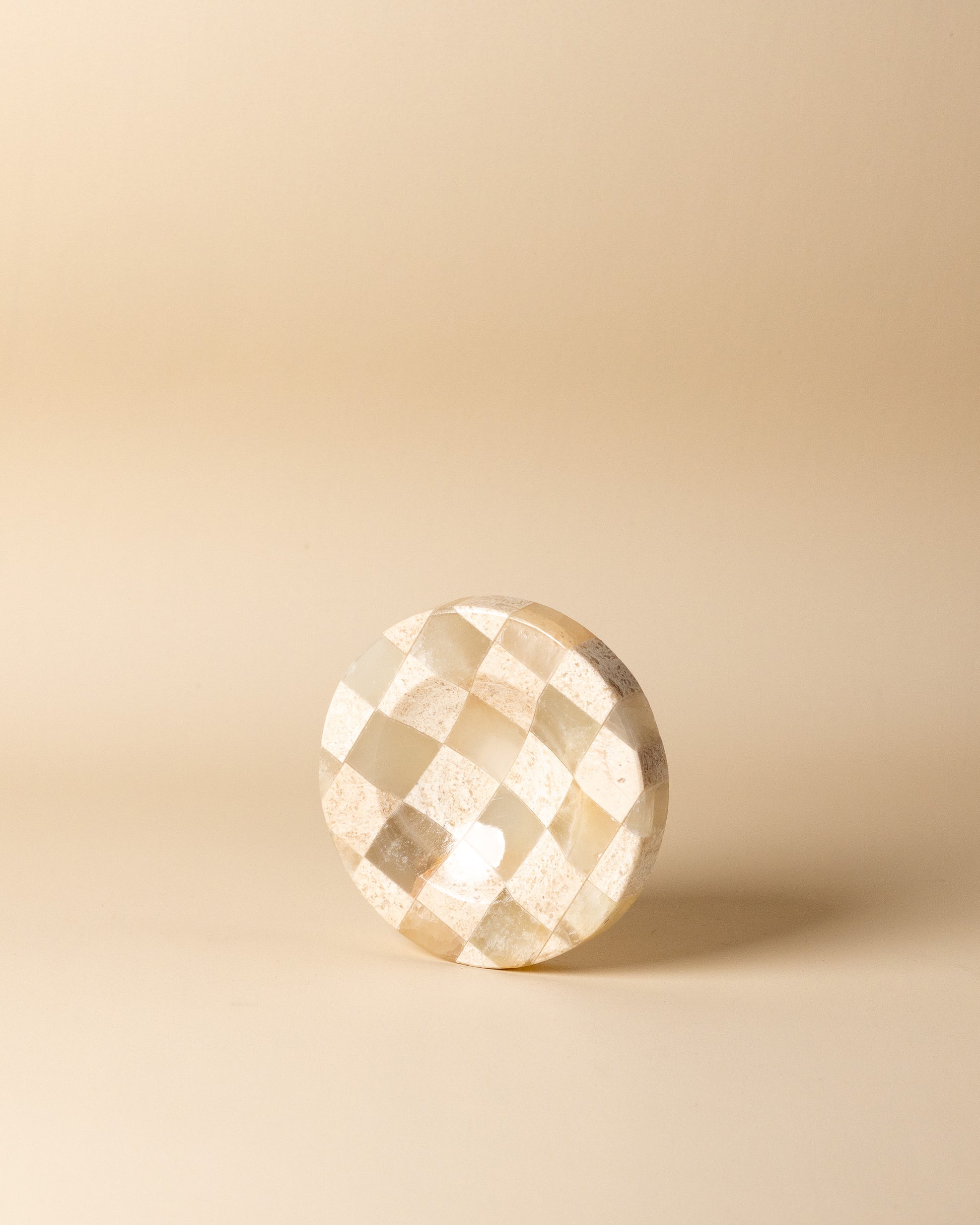 Geometrische Draufsicht auf das kleine, karierte Natursteintablett im Schachmuster von Marmonix, elegant inszeniert als luxuriöse Schmuck- oder Schlüsselablage.