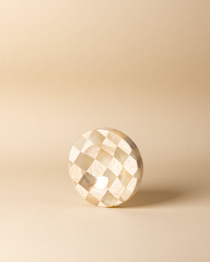 Geometrische Draufsicht auf das kleine, karierte Natursteintablett im Schachmuster von Marmonix, elegant inszeniert als luxuriöse Schmuck- oder Schlüsselablage.