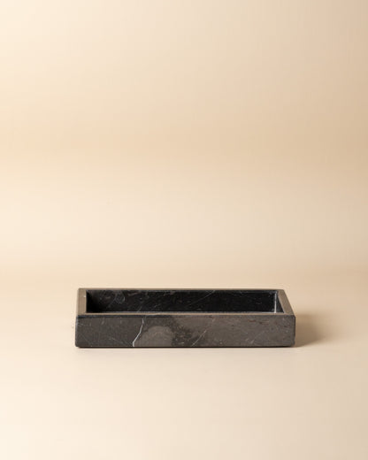 Black rectangular marble tray on a beige background